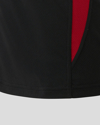 Close-up of black textured fabric from Saracens training tee with a red side panel.
