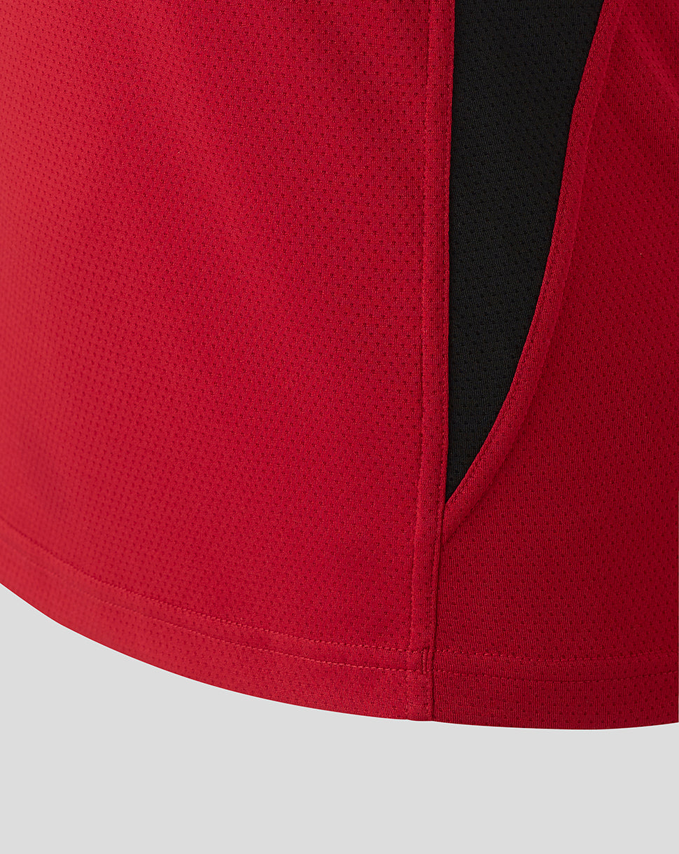 Close up of red breathable fabric on the Saracens training tee showing perforated mesh and a black side panel.
