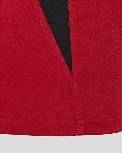 Close-up of red Saracens training vest fabric with a black angular panel.