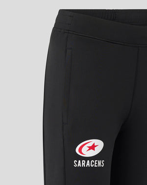 Close-up of black Saracens training pants with a white Saracens logo on the thigh