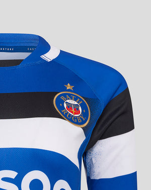 Close up of Bath Rugby home replica shirt chest showing crest on royal blue fabric with black and white stripes