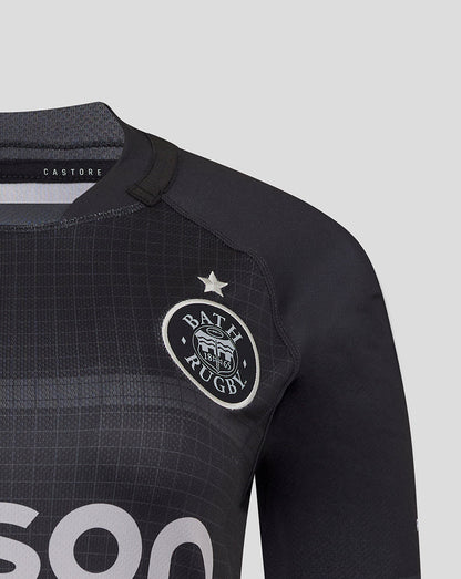 Close up of Bath Rugby crest on black replica shirt with grid texture and Castore label visible at collar