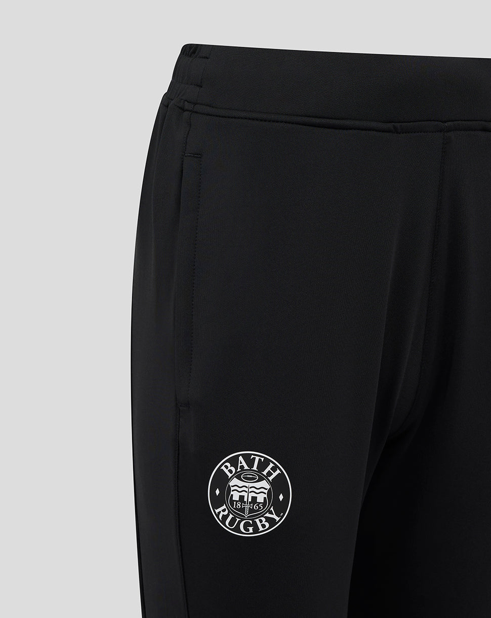 Close-up of the elasticated waistband and Bath Rugby emblem on the leg of black training pants.