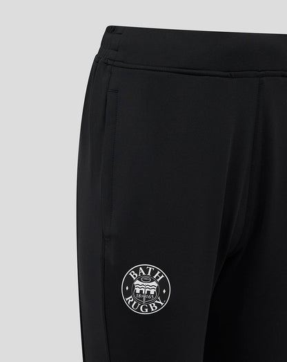 Close-up of the elasticated waistband and Bath Rugby emblem on the leg of black training pants.