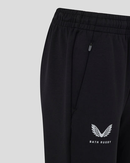 Close-up of black Bath Women Travel Knit Pants showing elastic waistband with zipper pocket and Bath Rugby logo near the hem