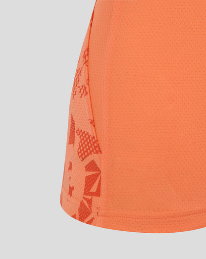 Close-up of melon colored England Rugby women's performance sleeveless top showing dotted fabric and abstract side panel print.