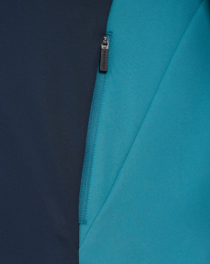 Close-up of navy and teal colorblock fabric with a Castore branded zipper pull