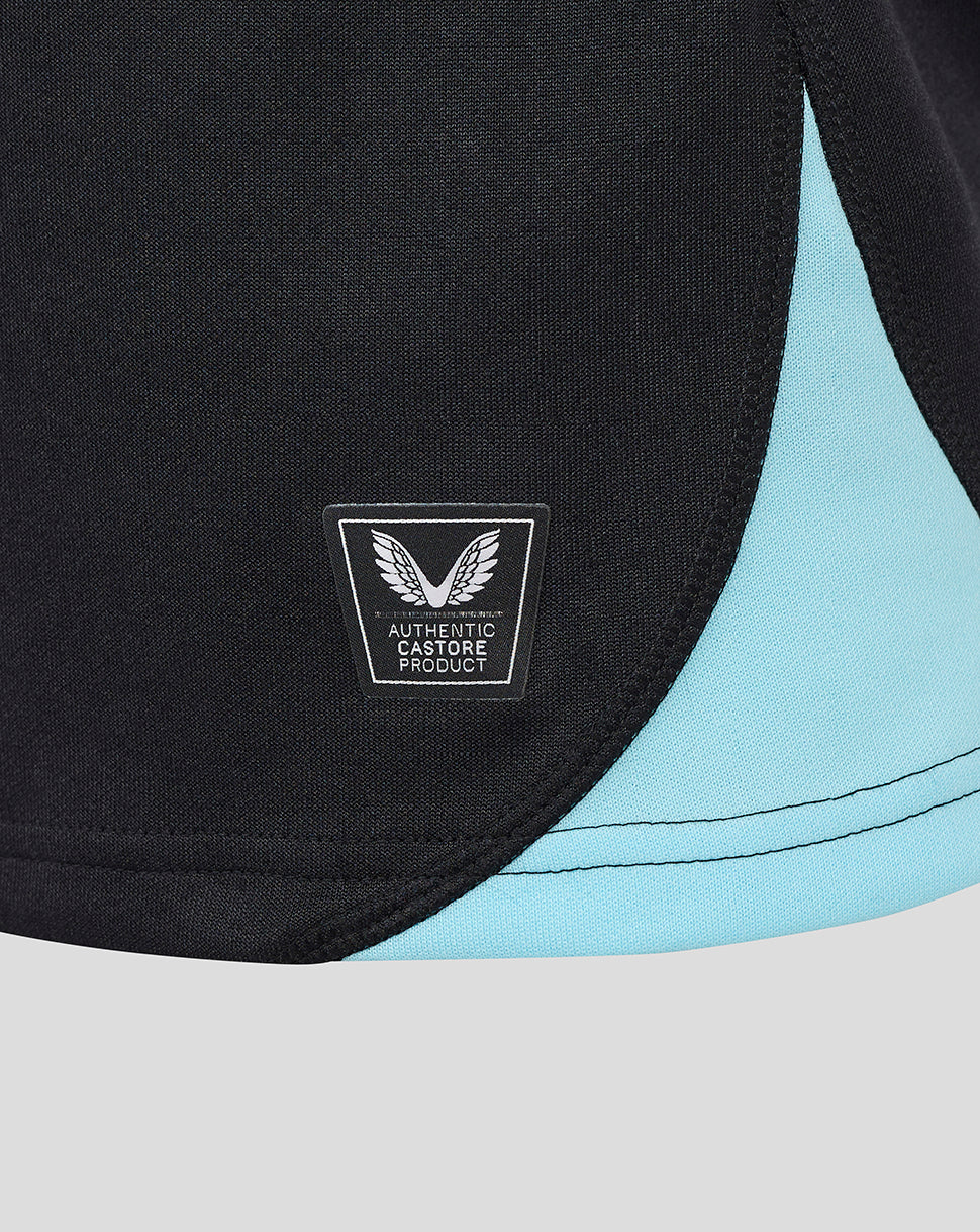 Close-up of black rugby shirt fabric with light blue trim and authentic Castore product patch