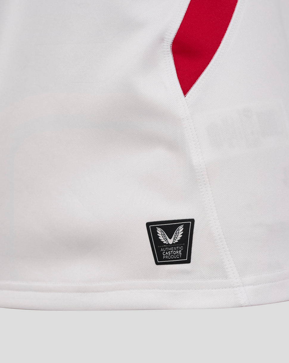 Close-up of white England rugby shirt showing red side panel and sleeve trim with Castore authenticity badge at the hem