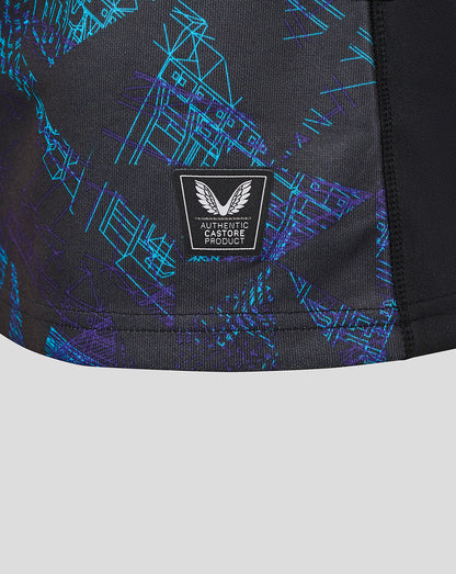 Close-up of lower front of the shirt with blue geometric print and an Authentic Castore Product badge.