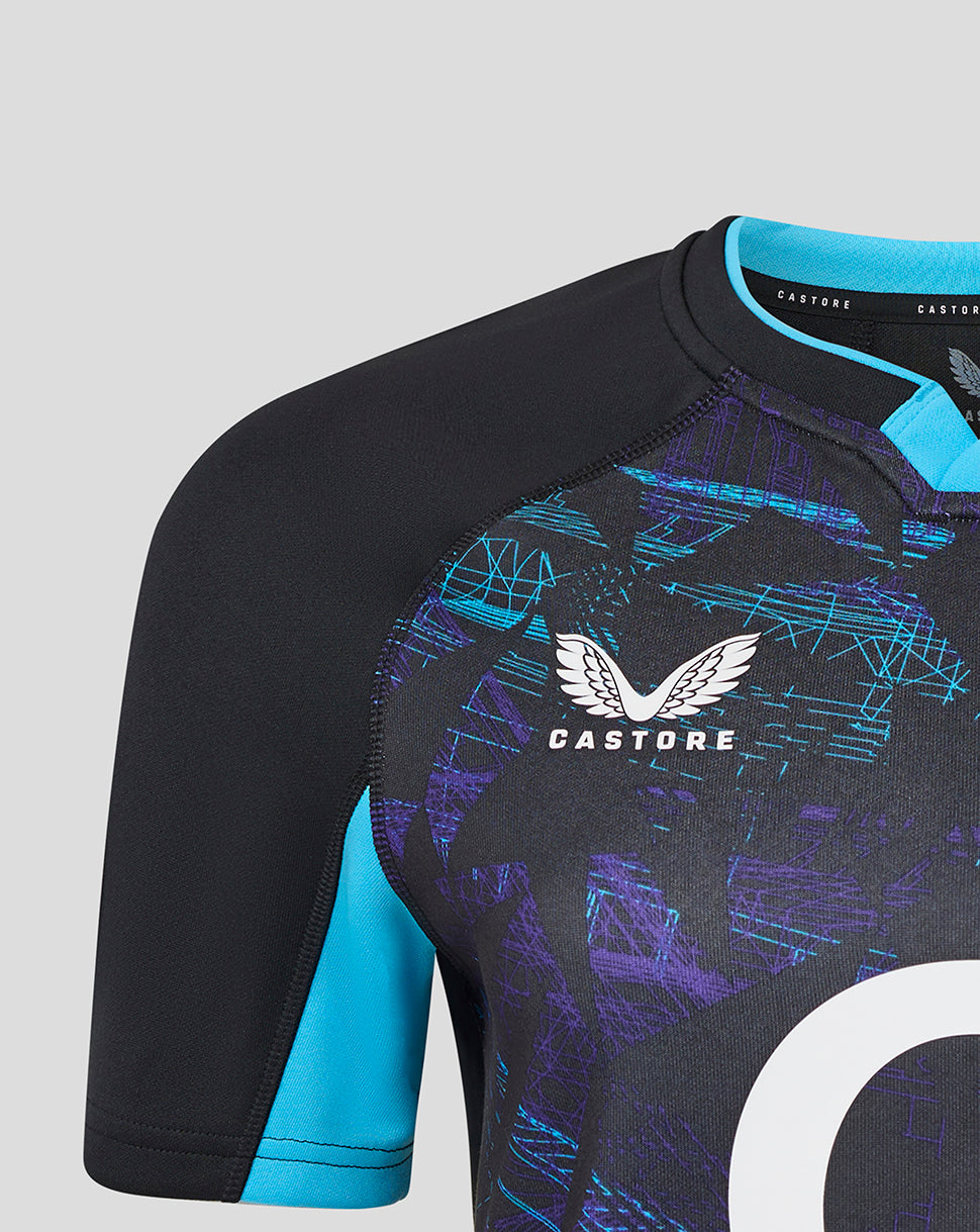 Close-up of Womens England Rugby Alternate shirt showing black body with turquoise sleeve panel and large white circular graphic on front.