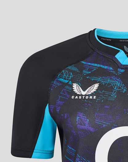 Close-up of Womens England Rugby Alternate shirt showing black body with turquoise sleeve panel and large white circular graphic on front.
