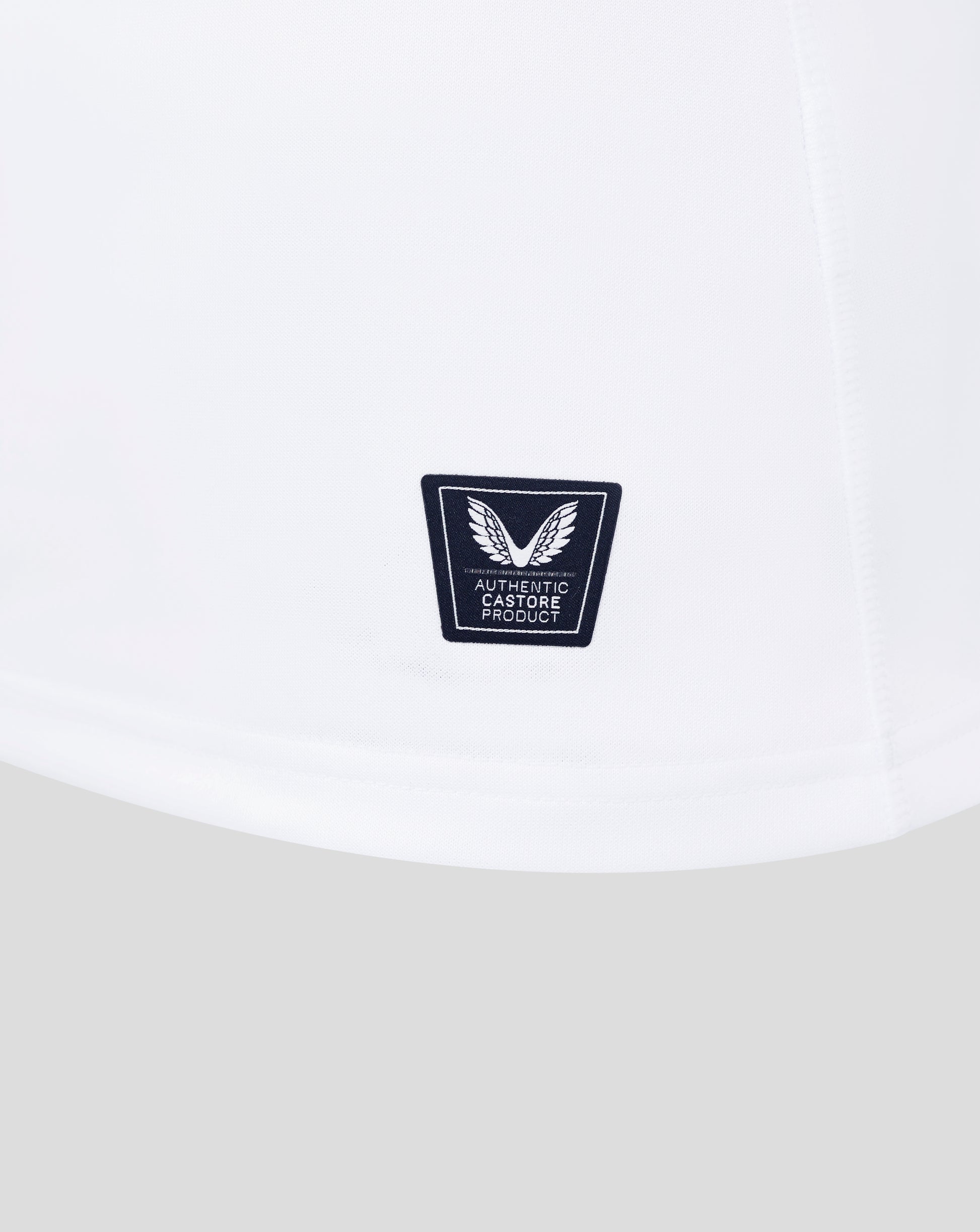 White fabric close up showing Castore authentic product badge near the hem