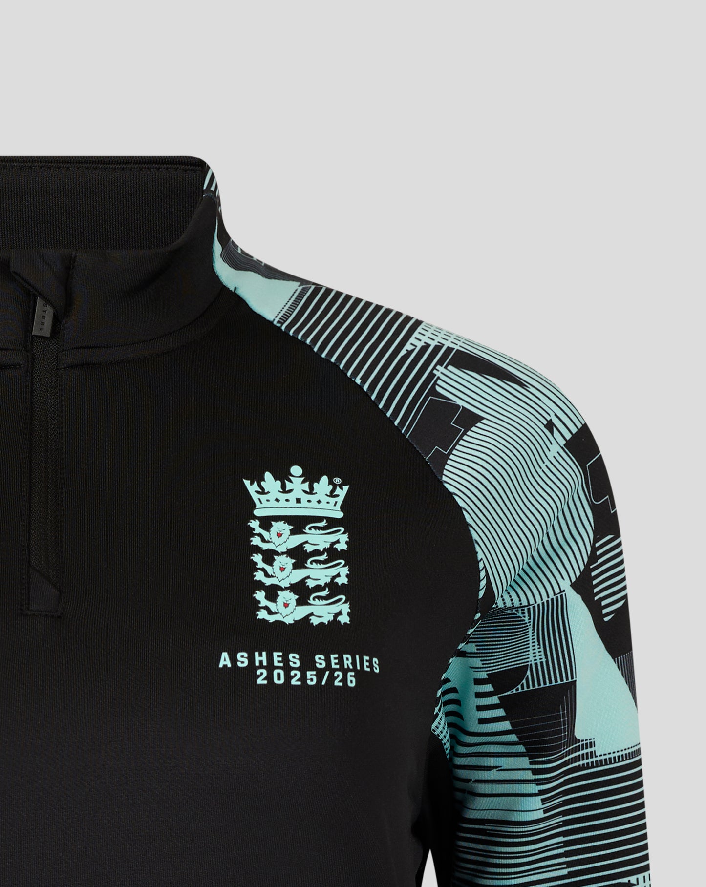 England Ashes Pro Quarter Zip Training Top in black with turquoise patterned sleeve and chest crest