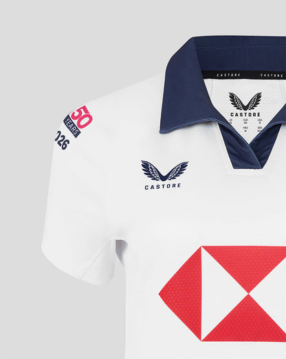 White jersey close up with navy polo collar Castore branding and a dragon crest on the chest.