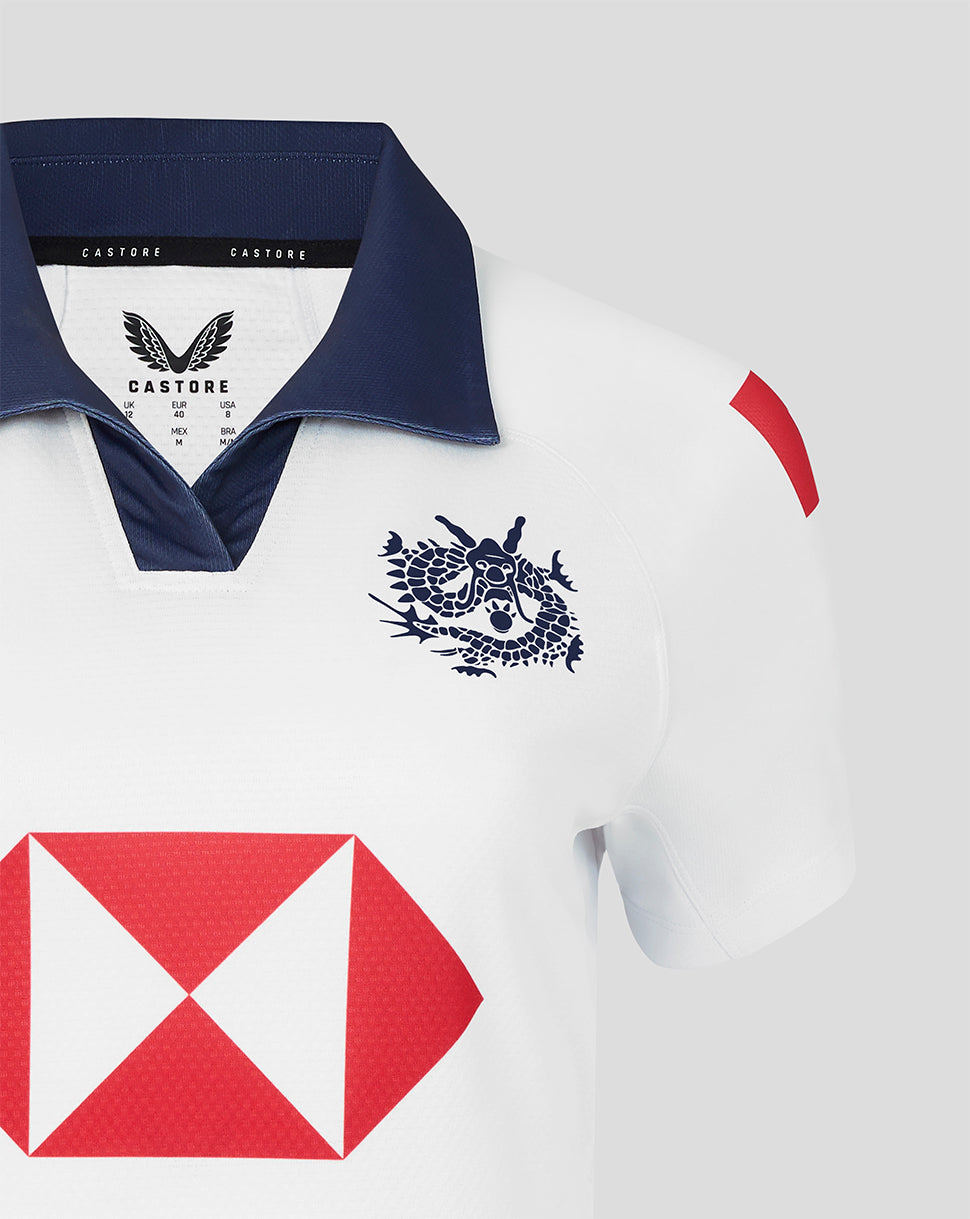 White HK7s jersey with navy collar and a bold red geometric emblem on the chest.