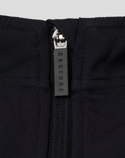 Close up of the zipper on a black womens track jacket at the funnel neck with quilted panels