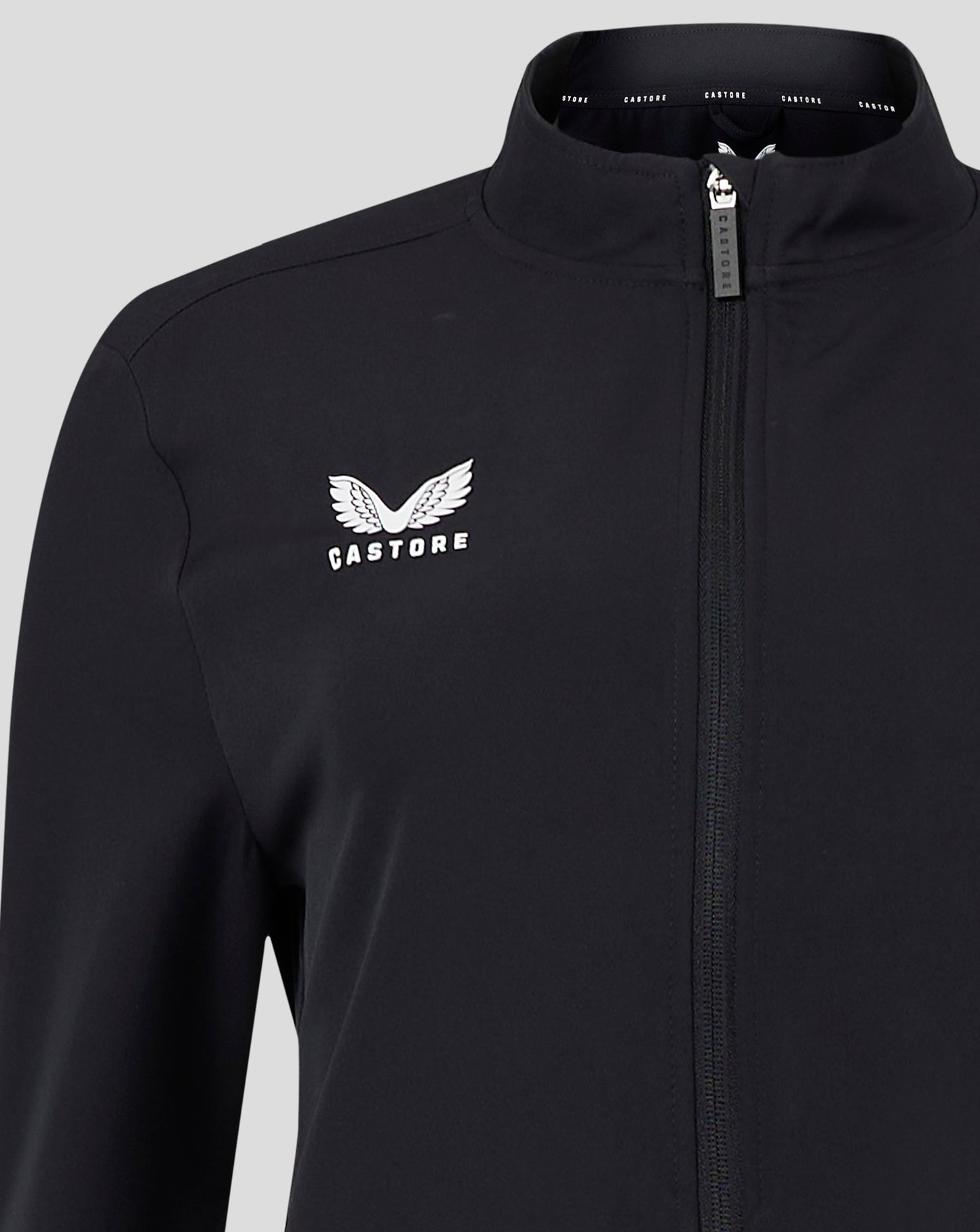 Collar interior of black jacket with CASTORE branded tape and a white wing Castore logo on the chest