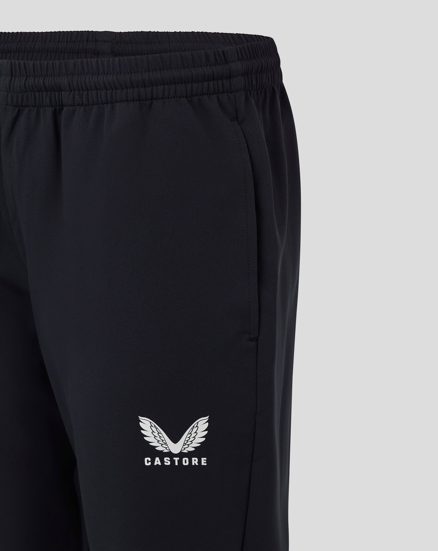 Close up of black womens track pant waist showing drawcord and heat sealed Castore logo on the leg