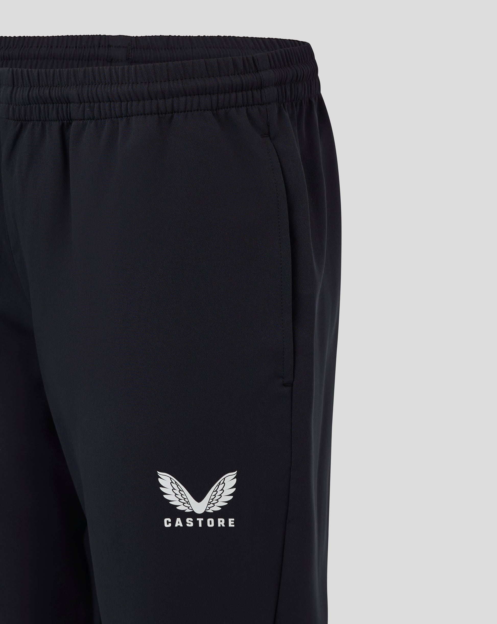 Close up of black womens track pant waist showing drawcord and heat sealed Castore logo on the leg