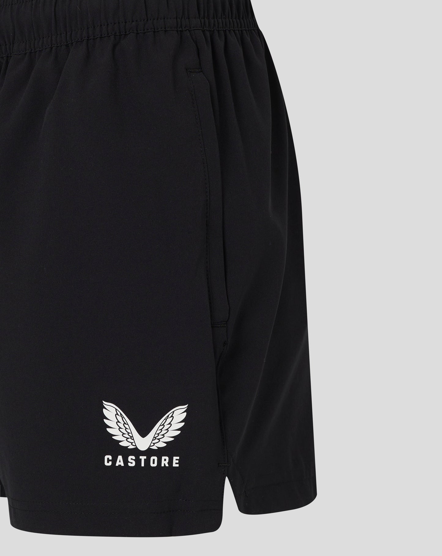 Back view of black woven training shorts showing elastic waistband and pocket seam