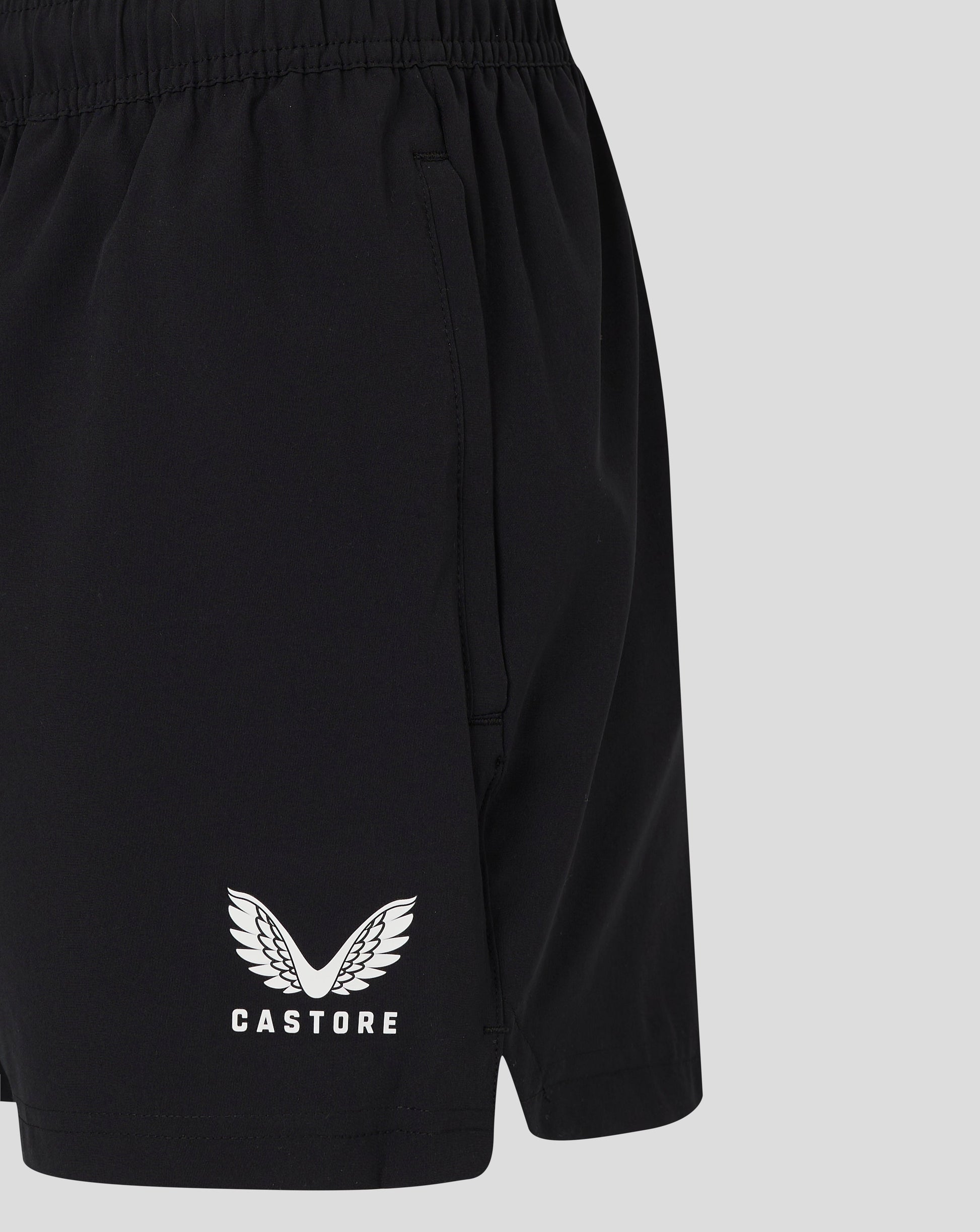 Back view of black woven training shorts showing elastic waistband and pocket seam