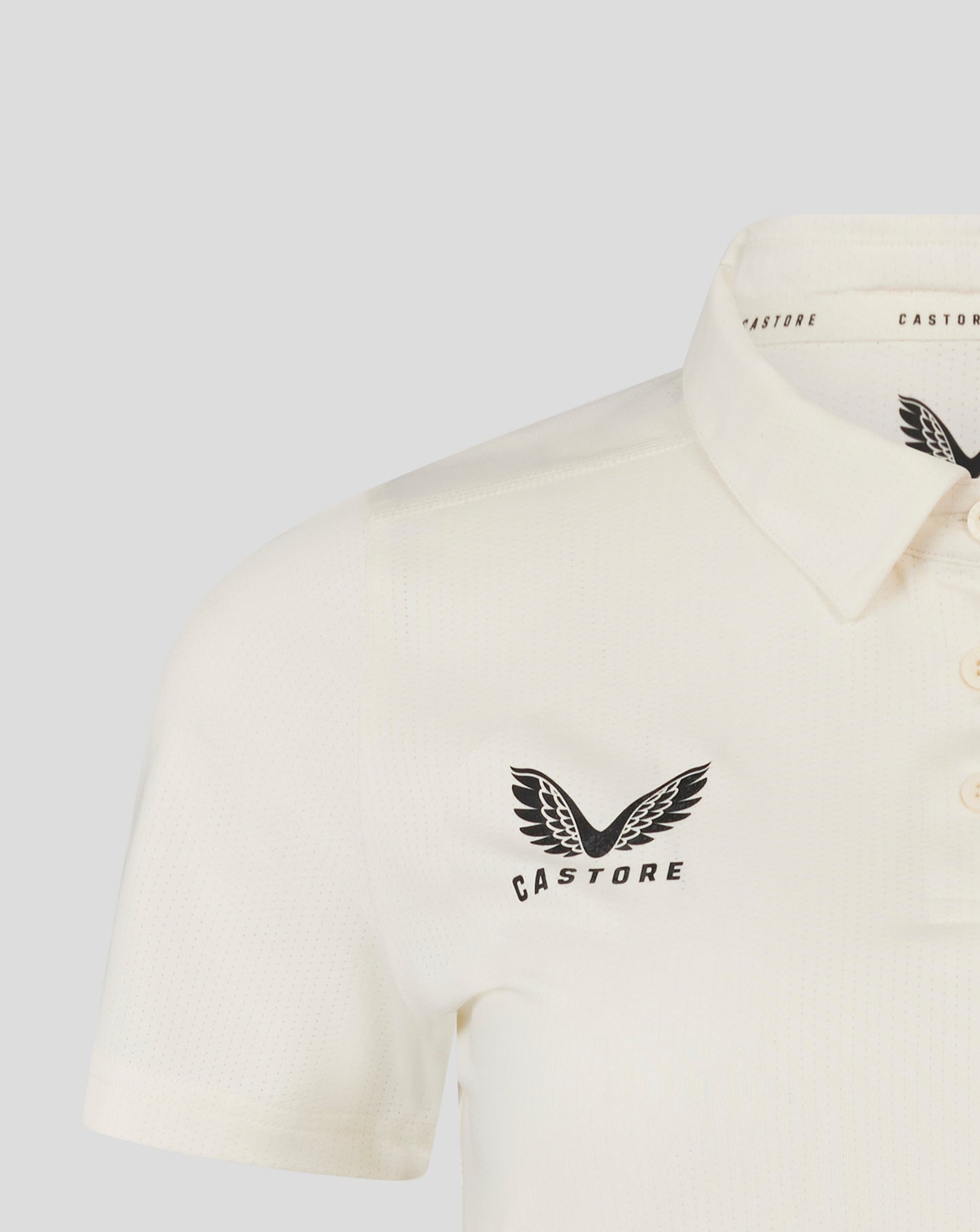 Cannoli Cream womens cricket tech playing shirt close up showing 3 button placket and Castore logo on chest