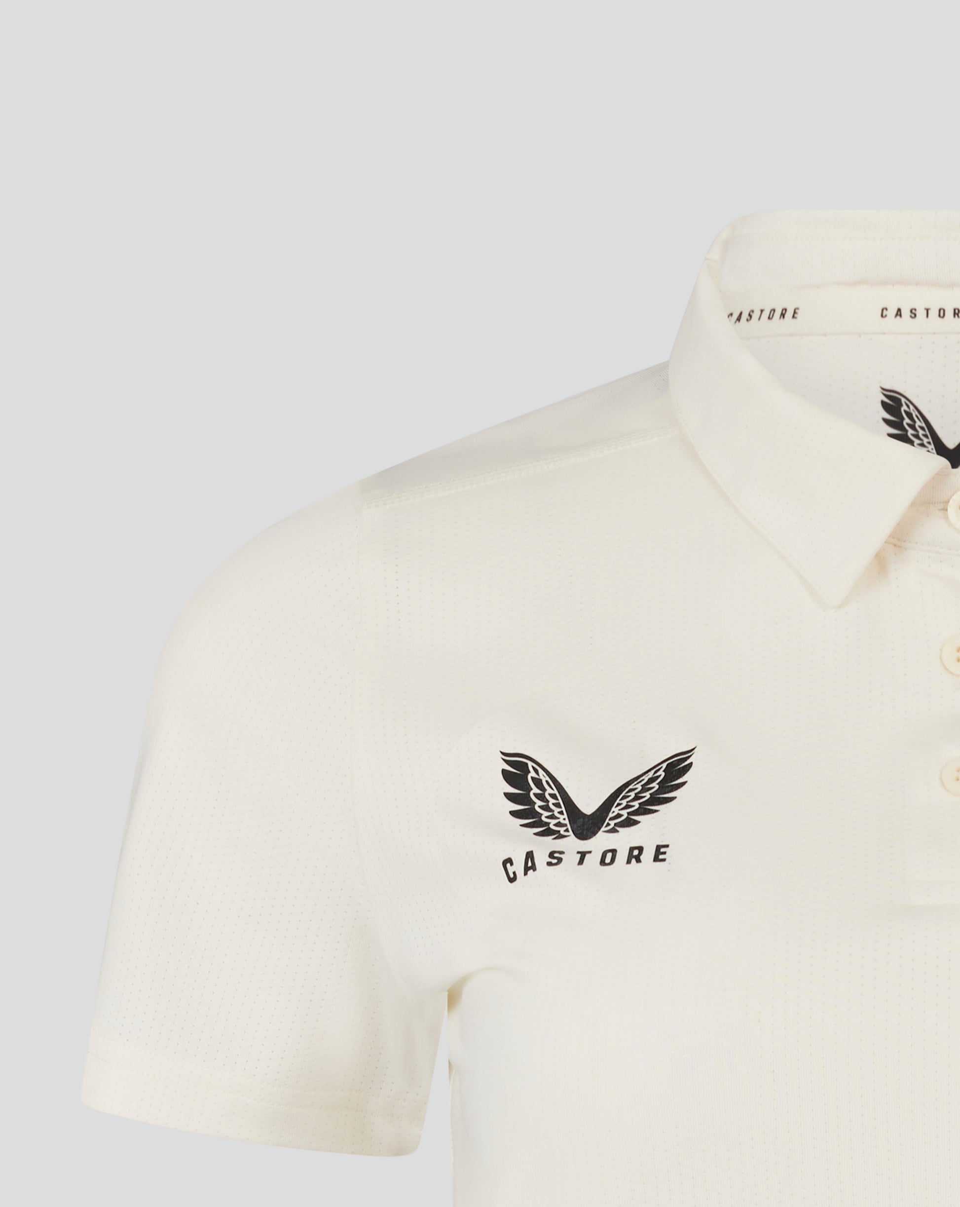 Cannoli Cream womens cricket tech playing shirt close up showing 3 button placket and Castore logo on chest