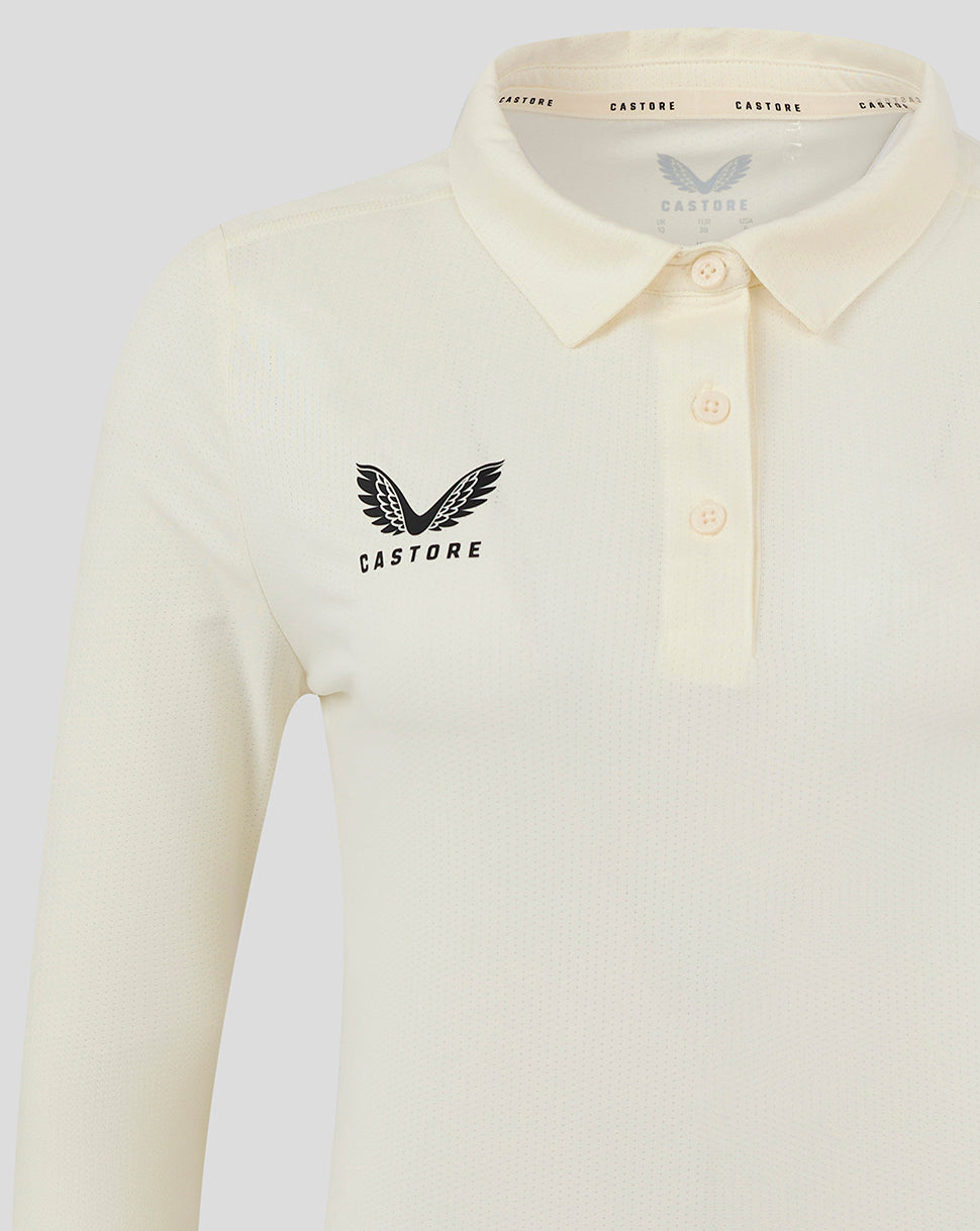Close up of Cannoli Cream polo style cricket shirt showing collar three button placket and left chest Castore logo