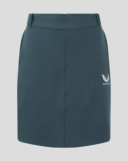 Front view of dark slate Womens Chino Skirt with a white Castore logo at the lower right.