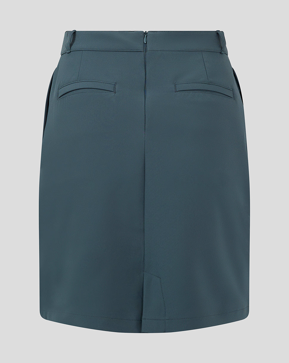 Back view of dark slate Womens Chino Skirt with two welt pockets and a Castore logo near the hem.