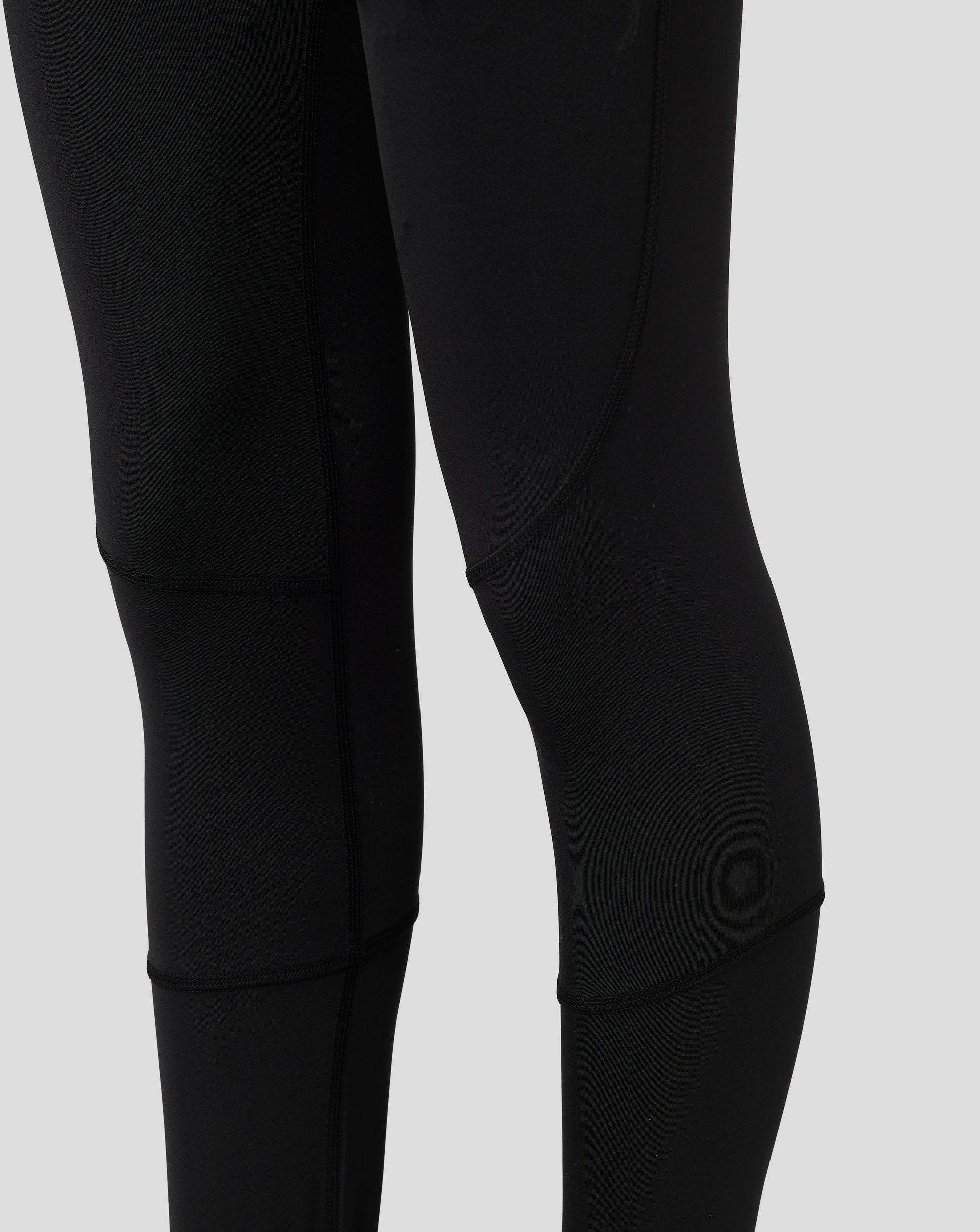 Close up of black Baselayer Legging fabric showing paneling and flatlock seams