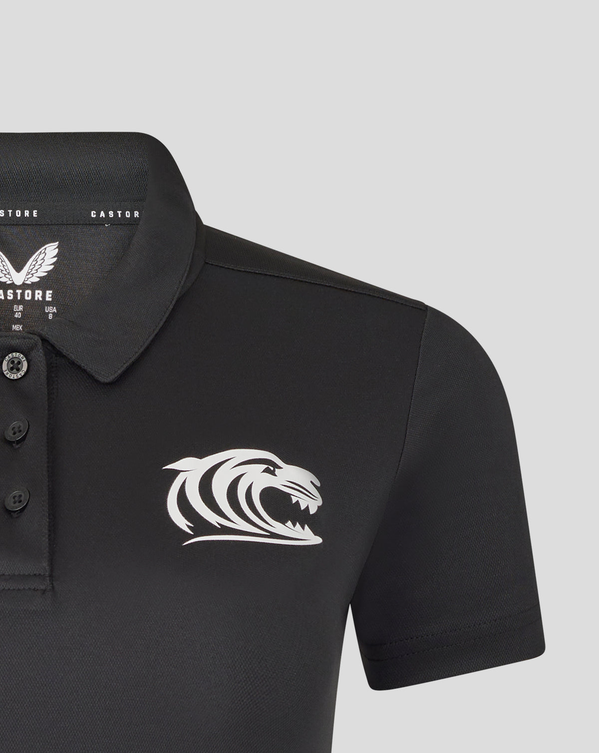 Close up of black polo chest featuring tiger crest on the left and branding at the collar interior