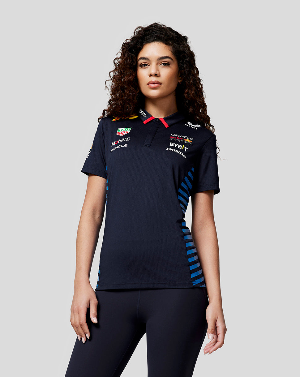 Female model wearing navy Night Sky Oracle Red Bull Racing Teamline short sleeve polo front view with sponsor logos and blue side panels.