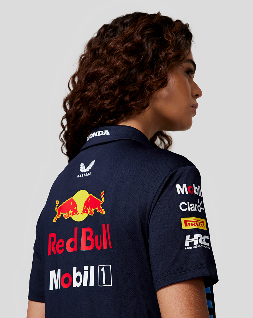Back view of a woman in navy Night Sky Teamline polo showing large Red Bull logo on the back