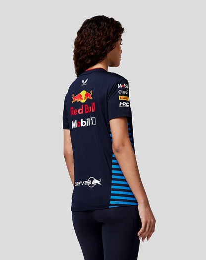 Back view of a woman in a navy Red Bull Racing Set Up T Shirt with large Red Bull logo and sponsor patches and blue side stripes.