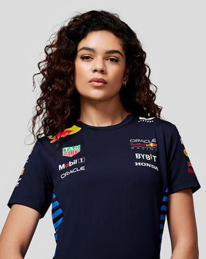 Front view of a woman wearing a navy Set Up T Shirt with team logos and breathable side mesh panels.