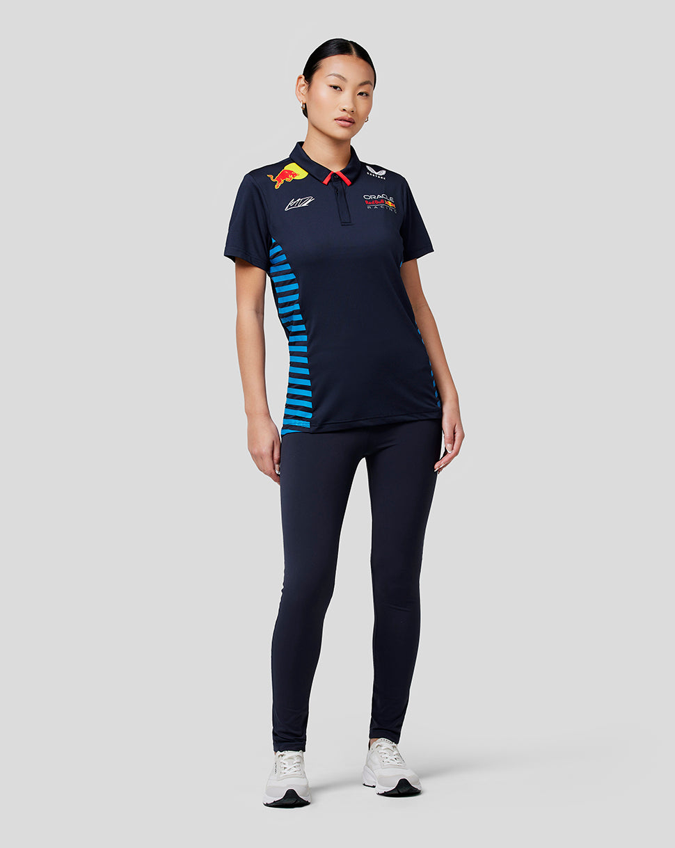 Front view of a woman wearing a navy Oracle Red Bull Racing Women Teamline polo with logos on the chest and blue side panels