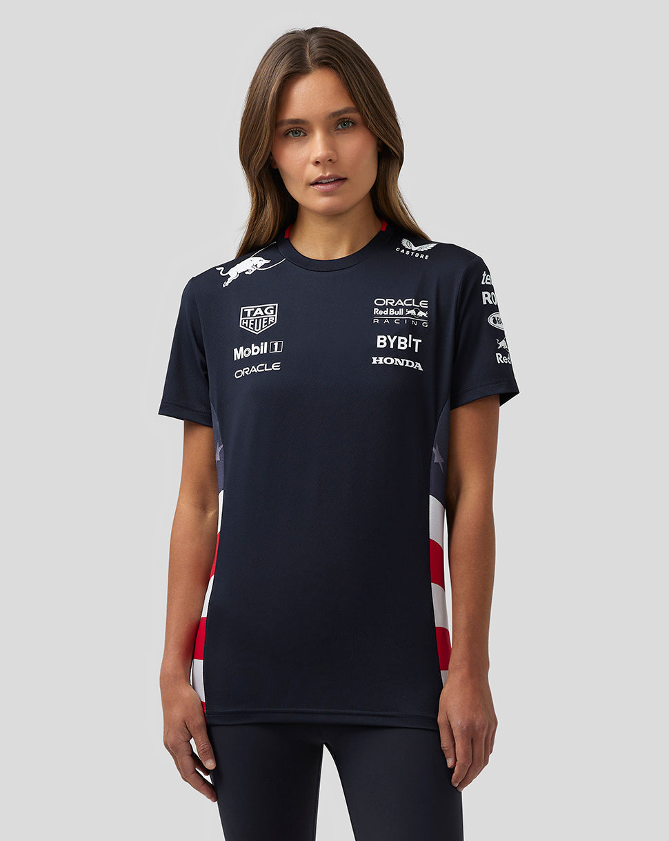 Front view of a woman wearing a navy America Race Team T Shirt with sponsor logos on the chest and red white checkered side panels