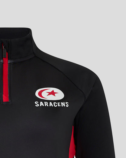 Close up of black Saracens 24/25 matchday 1/4 zip top with red zipper and chest crest
