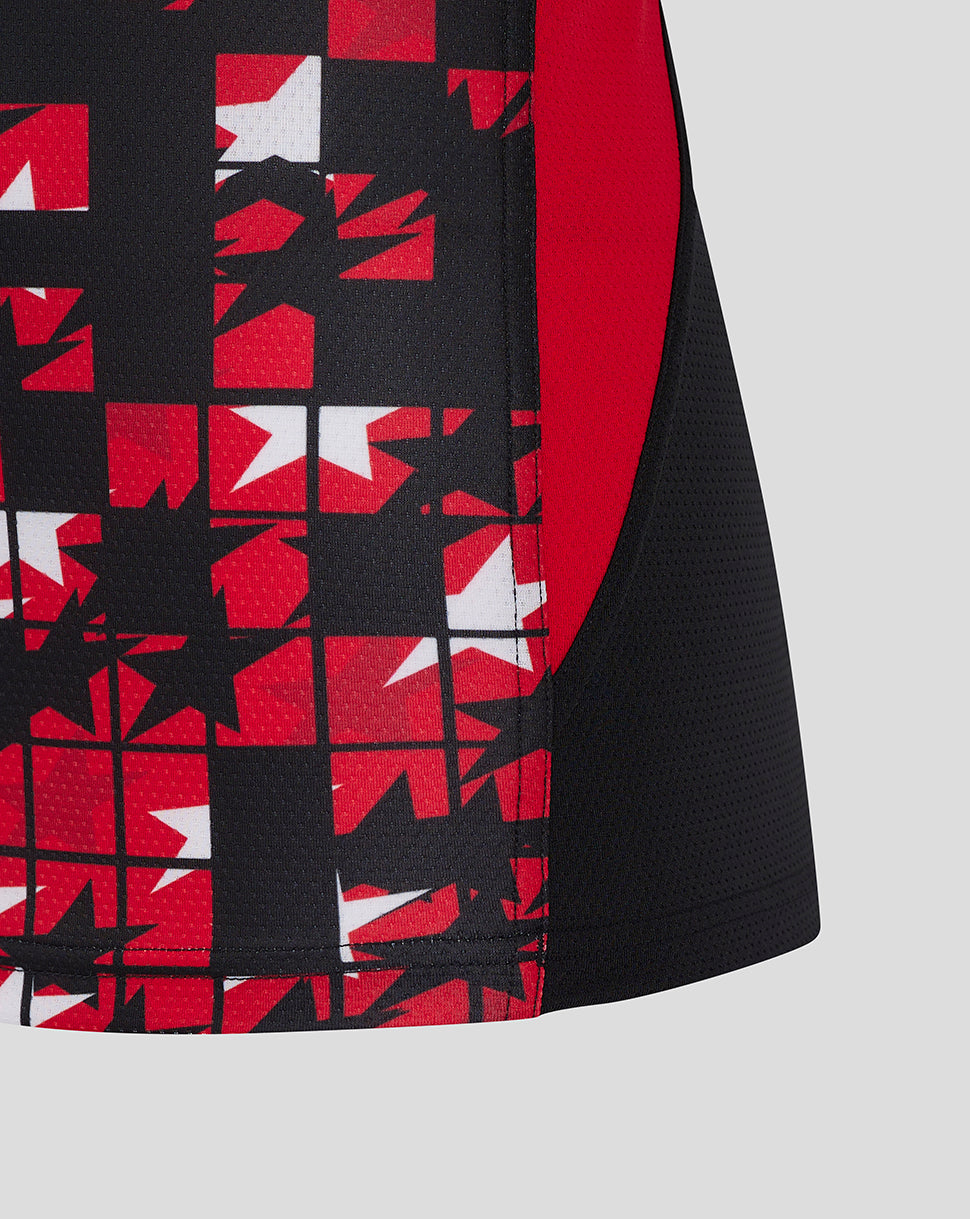 Close up of red and white geometric tile pattern on the lower front of the black tee