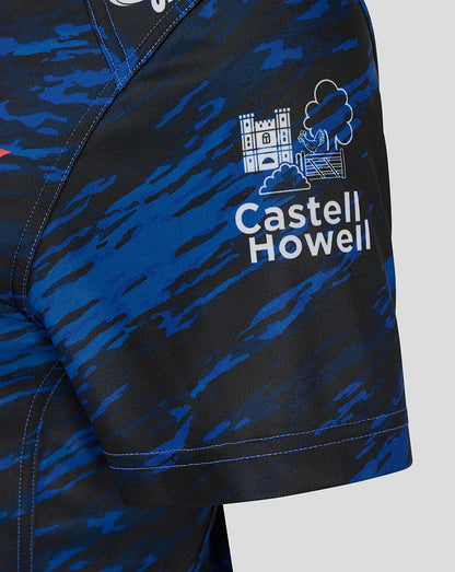 Close up of the Scarlets Away Shirt sleeve area displaying the Castell Howell logo and castle icon on blue camouflage fabric.
