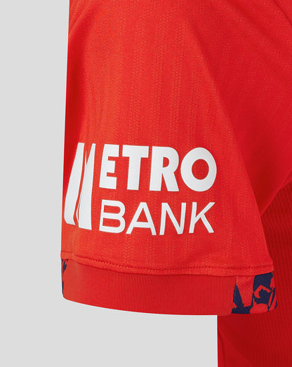 Close-up of red England women's 24/25 T20 shirt fabric with Metro Bank sponsor on the hem
