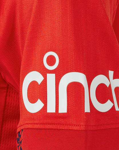 Close-up of red fabric with a large white Cinch logo on the sleeve area