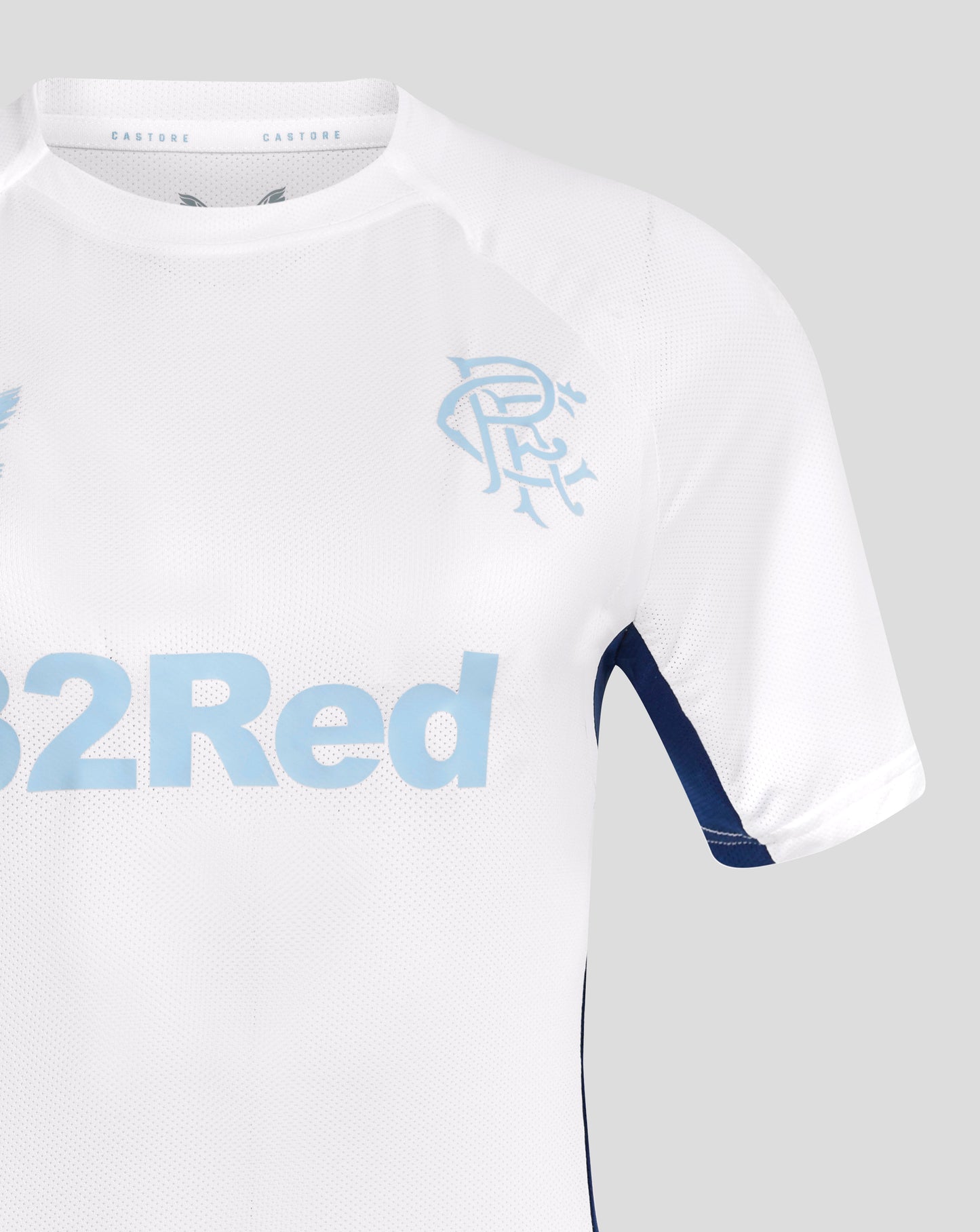 Close up of white Rangers jersey collar area with light blue crest on the chest and Castore label inside the neck navy sleeve trim visible