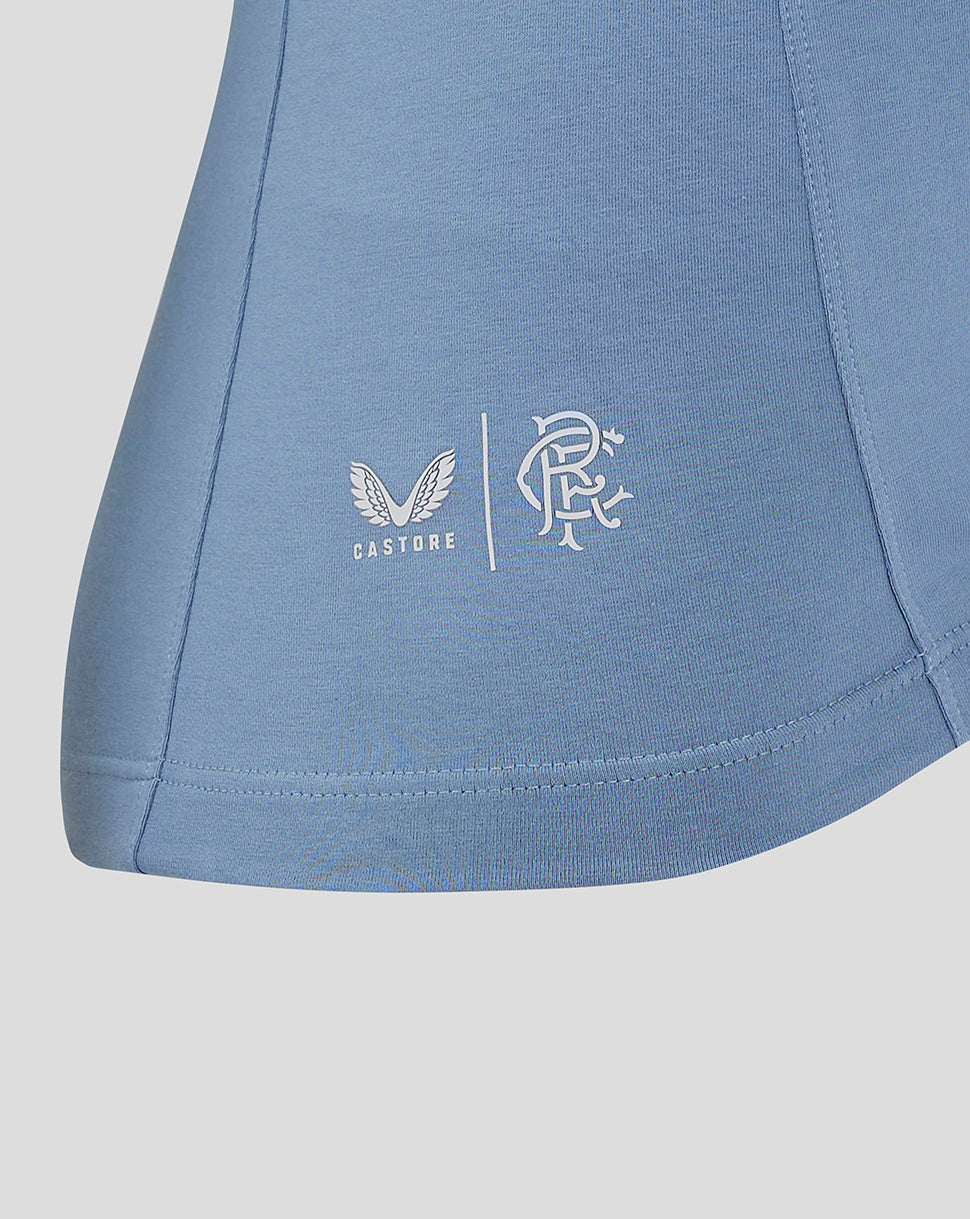 Close-up of Castore wings and club crest logos on the hem of the light blue Rangers Travel Polo