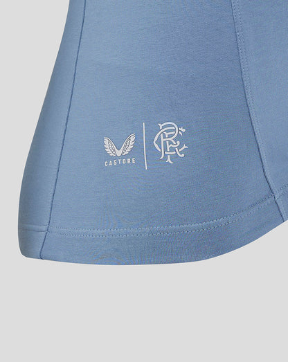 Close-up of Castore wings and club crest logos on the hem of the light blue Rangers Travel Polo
