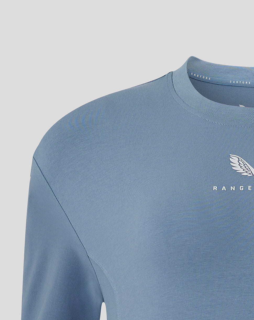 Close up of chest area on light blue Rangers Travel T Shirt showing the club crest and Castore branding.