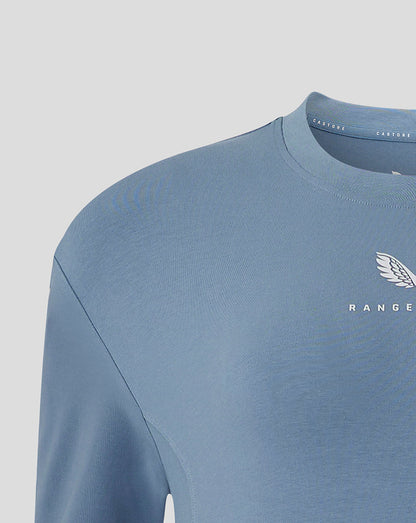Close up of chest area on light blue Rangers Travel T Shirt showing the club crest and Castore branding.