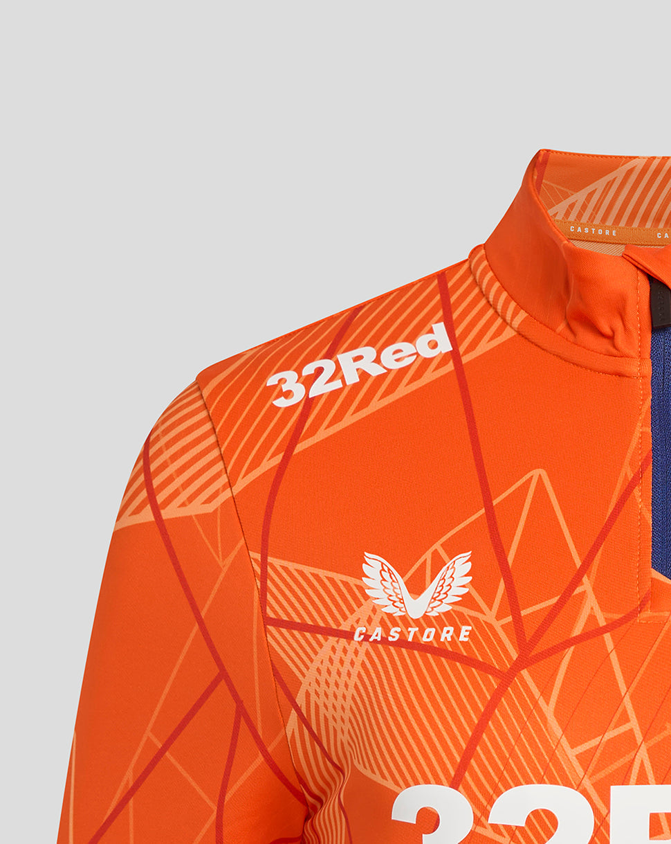 Close-up of the orange midlayer chest area showing 32Red branding and Castore emblem with the geometric pattern.
